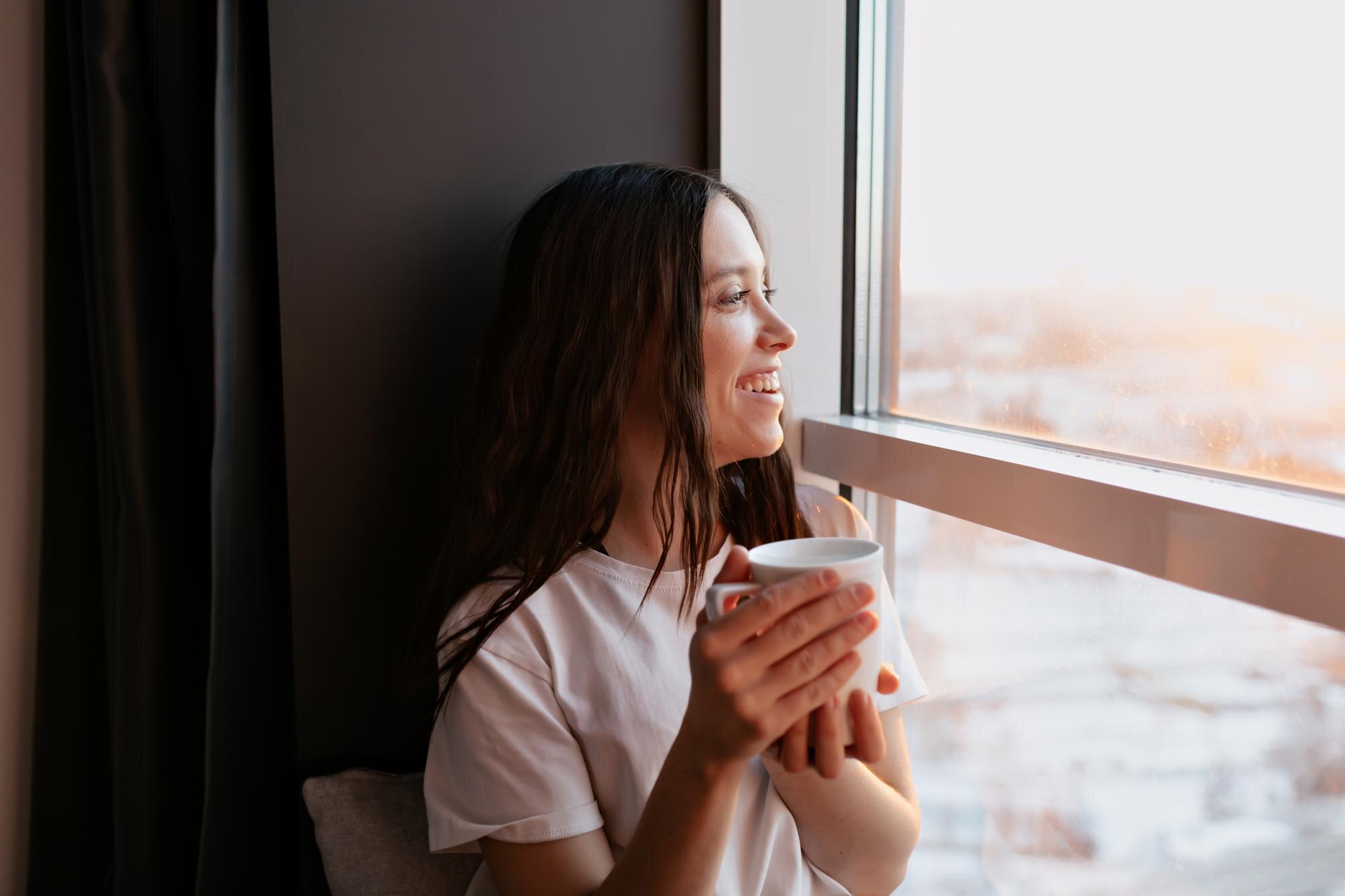 Mujer relajando la vista frente a una ventana